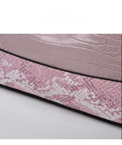 Detail display of pink shoulder bag showing marble embossing and faux snake skin texture