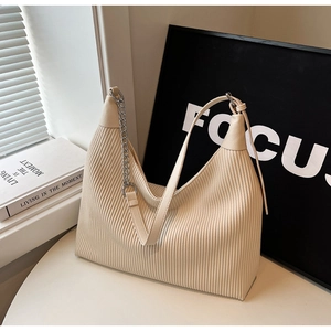 Détail du sac hobo plissé beige avec chaîne argentée et bandoulière en cuir lisse