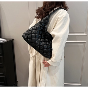 Detailed view of black quilted puffer shoulder bag with soft textured material and large capacity