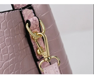 Detail of light purple crocodile embossed leather bag with gold metal swivel hook hardware