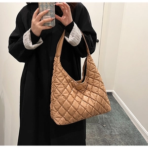 Detail of camel quilted hobo bag with diamond stitching shown on a model's shoulder