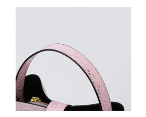 Detailed close-up of pink snakeskin texture handle and premium gold zipper on handbag