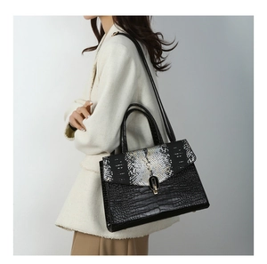 Detail of elegant crocodile and snakeskin texture handbag with gold metal clasp