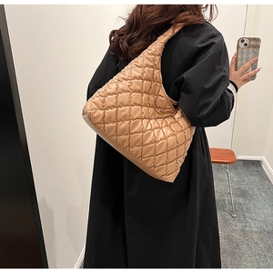 Detailed close-up of khaki quilted crossbody bag texture and large moon shape design