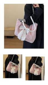 Detailed view of pink plush tote bag with white bow and woven rope handles