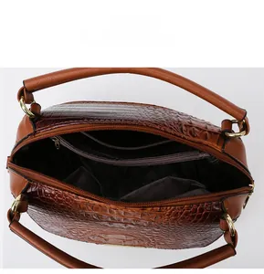 Detailed interior of brown crocodile pattern handbag with zipper and slip pockets