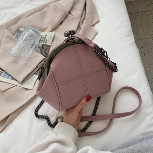 Pale pink leather shell crossbody bag with metal kiss-lock and quilted stitching details