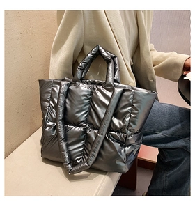 Detailed view of silver quilted down tote bag with a high-gloss metallic finish and soft texture