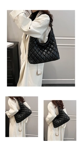 Detail of black quilted shoulder bag featuring premium texture and bronze metal chain strap
