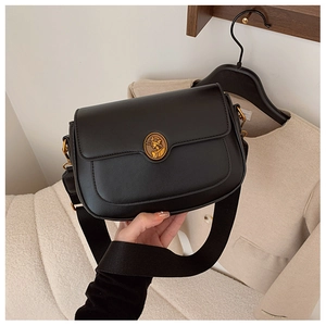 Detailed view of black textured leather bag with vintage golden lady portrait buckle