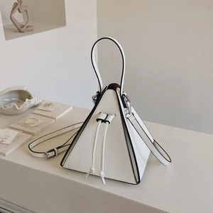Détail d'un sac triangle en cuir blanc avec bordures noires et poignée supérieure