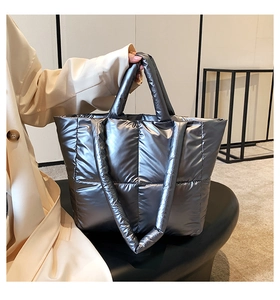 Detail of silver metallic quilted tote bag with padded handles and large square stitching