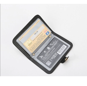 Close-up of black lychee leather bifold card holder with two transparent ID slots and gold snap