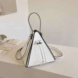 Gros plan du sac triangulaire géométrique avec détails noirs sur support en pierre
