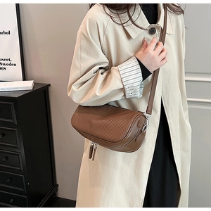 Detailed macro of brown cylindrical leather bag with fine texture and double zippers