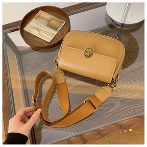 Detail of khaki PU shoulder bag with retro golden circular metal buckle and woven strap
