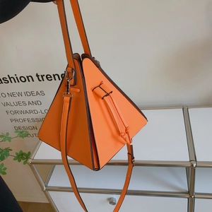 Détail du sac seau triangulaire géométrique orange vif avec fermeture à cordon