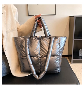 Close-up of metallic silver quilted down tote bag with high-capacity quilted fabric detail