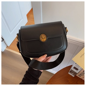 Close-up of vintage black crossbody bag featuring a golden portrait buckle and wide strap
