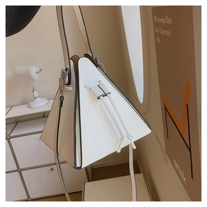 Gros plan détaillé du sac triangulaire blanc montrant les bords noirs et le cordon serrage