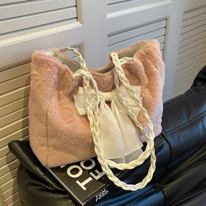 Pink plush faux fur tote bag with a white organza bow and woven handles