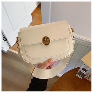 Detailed macro view of retro cream white leather bag with vintage metal portrait buckle