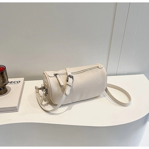 Detailed view of white pleated boston bag with silver hardware and adjustable strap