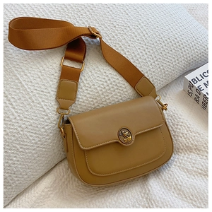 Detail of khaki leather square bag with vintage relief buckle and canvas strap