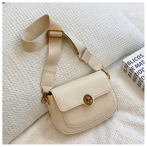 Close-up of cream square bag with vintage gold buckle and wide woven shoulder strap