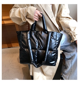 Close-up of black quilted puffer tote bag featuring soft padded nylon texture and large capacity