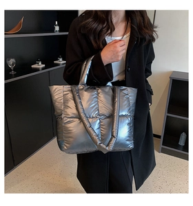 Chic silver quilted down tote bag worn with black coat for stylish winter fashion