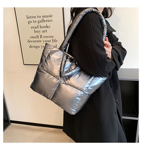 Detail of silver metallic quilted tote bag with puffer style texture and thick strap