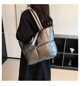 Detailed back view of a silver quilted puffer tote bag with metallic finish and thick straps