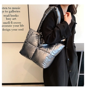 Detail of silver quilted tote bag with metallic finish shown on a shoulder