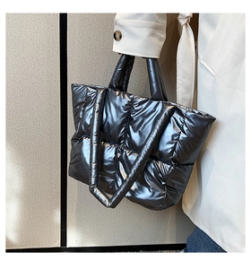 Side view of silver quilted tote bag with metallic finish and double straps