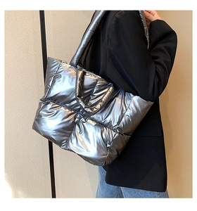 Side view of silver metallic padded tote bag with quilted down texture on a shoulder