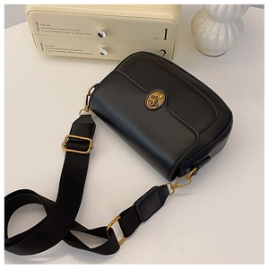Detail of black matte leather crossbody bag with vintage gold floral buckle and wide strap