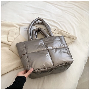 Detailed macro view of high-quality quilted down tote bag fabric in metallic silver finish
