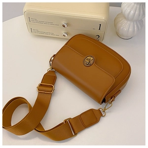 Detail of caramel leather crossbody bag with vintage metal buckle and nylon strap