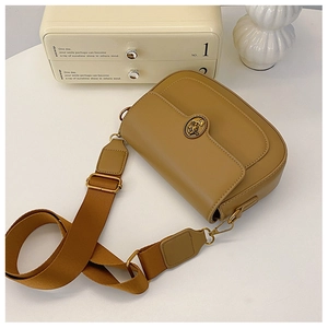 Detail of light brown retro saddle bag featuring a golden rose pattern metal buckle