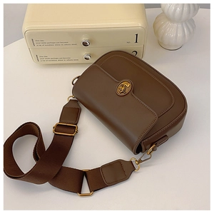 Detail of vintage brown crossbody bag featuring golden oval buckle and woven strap