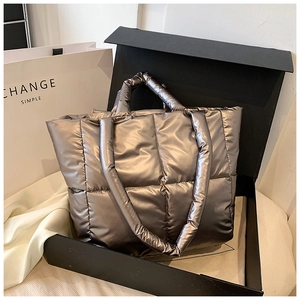 Detailed shot of quilted metallic tote bag inside a luxury gift box with shopping bag