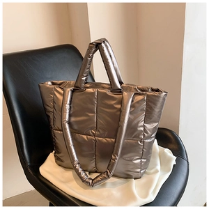 Detailed view of quilted puffer tote bag with metallic finish and soft padded texture