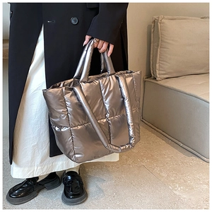 Close-up of metallic silver quilted tote bag featuring glossy fabric and puffy texture