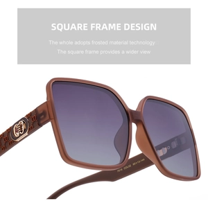 Close-up of temple detail on oversized square sunglasses with gold G logo and texture