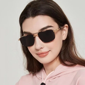 Detail of gold metal punk sunglasses featuring textured temples and black square lenses