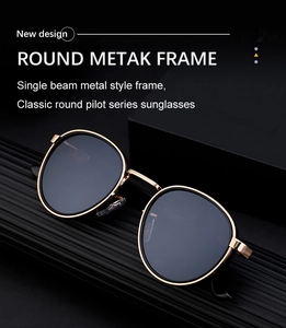 Classic round pilot sunglasses with gold metal frame and black lenses on a dark display