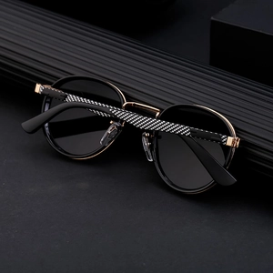 Detail of round punk sunglasses with carbon fiber texture arms and gold metal hinges