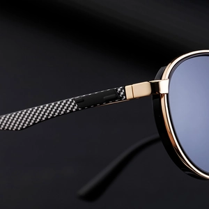 Close-up of gold metal sunglasses frame with carbon fiber pattern on the temple
