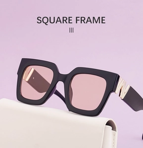 Close-up of square sunglasses with pink lenses and gold metal geometric temple hinge
